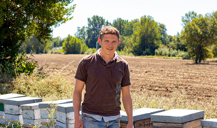 Photo du producteur de chia Jean François Monod devant des ruches
